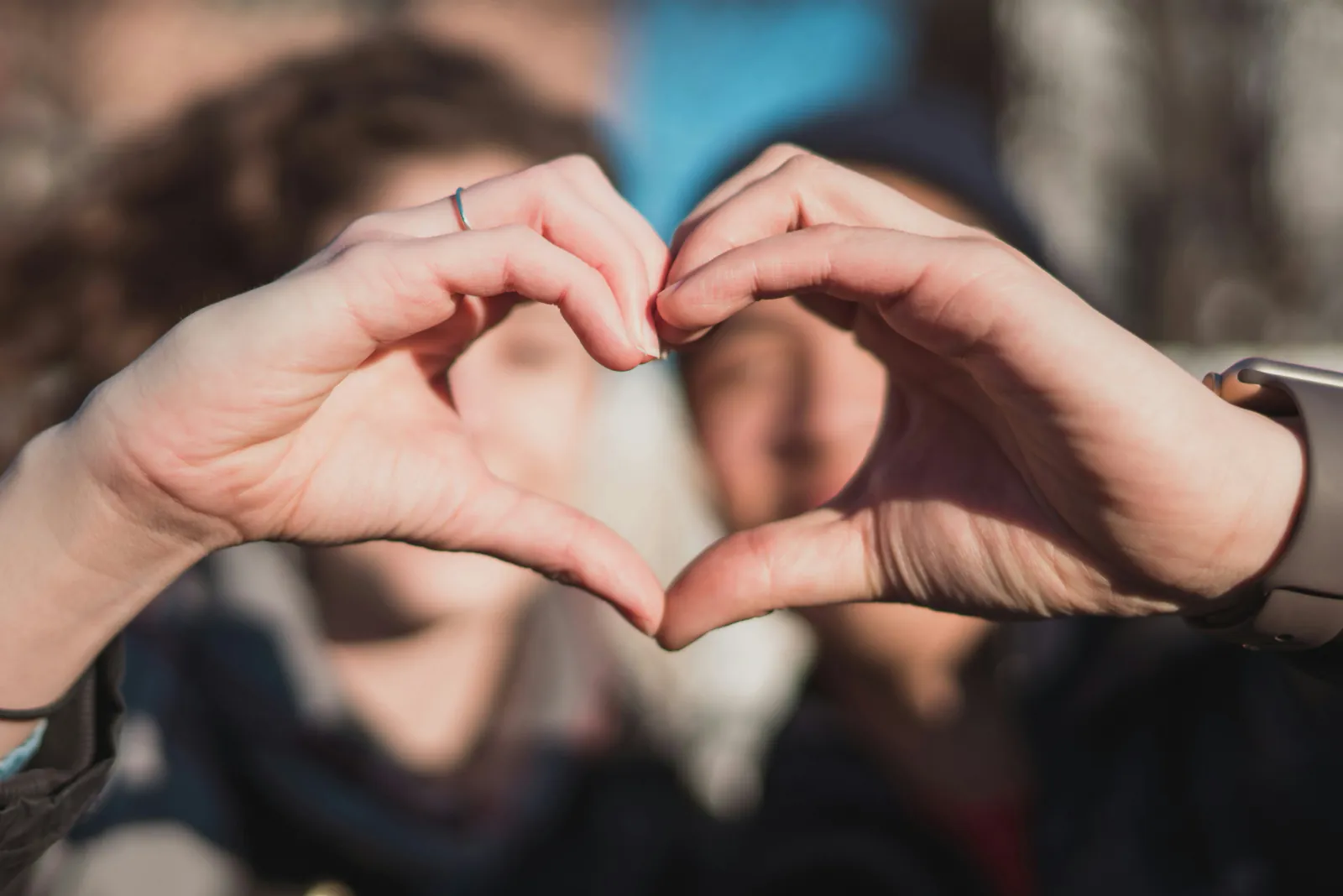 Young people making a heart shape with their hands