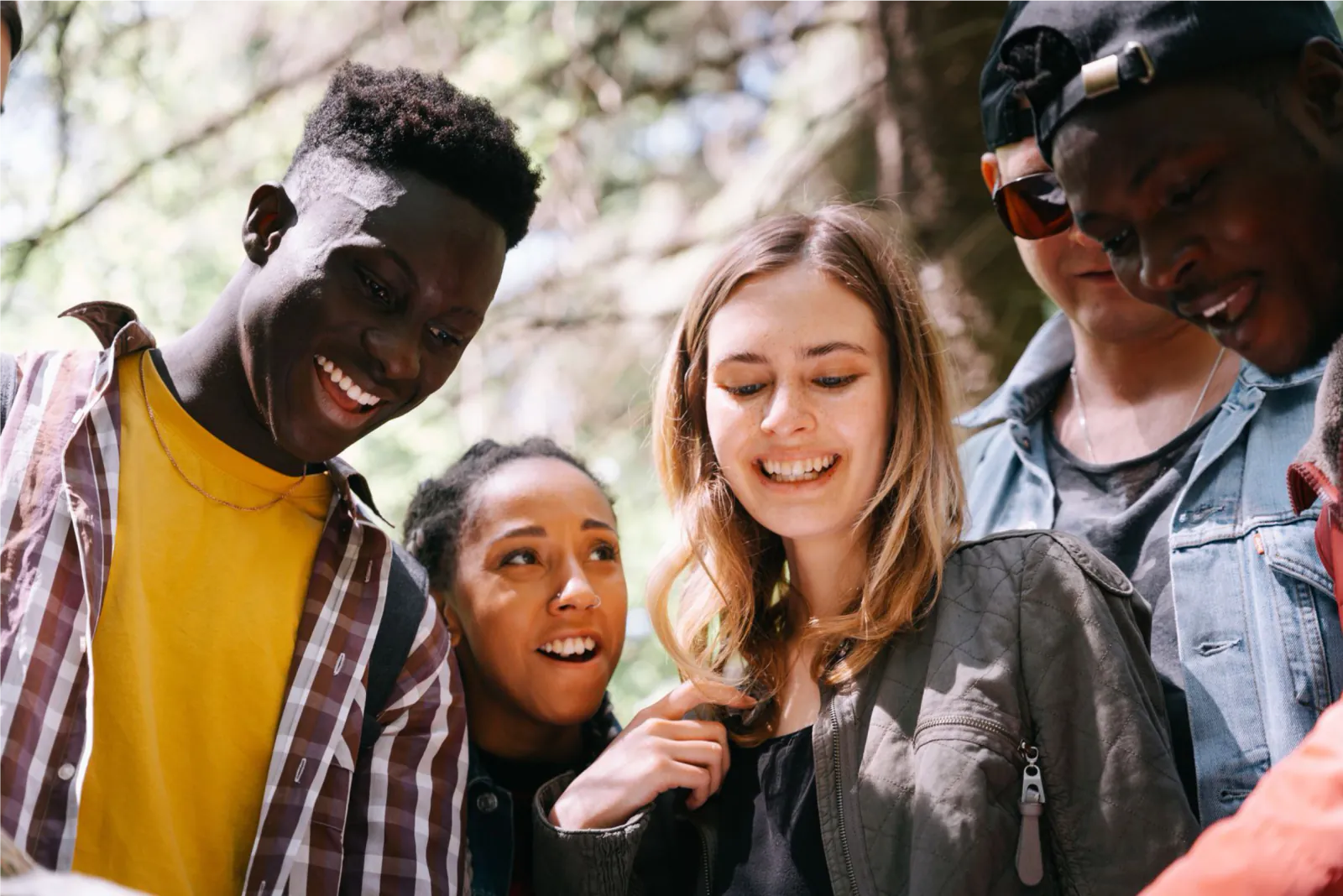 A diverse group of young adults sharing a joyful moment outdoors